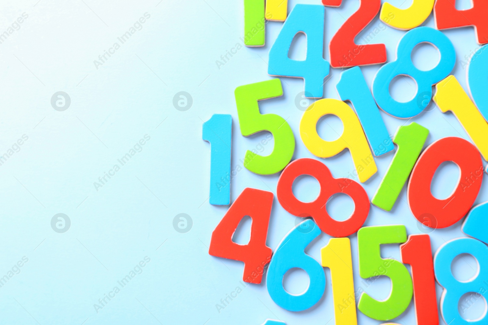 Photo of Colorful numbers on light blue background, flat lay. Space for text