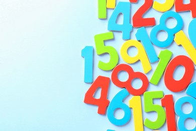 Photo of Colorful numbers on light blue background, flat lay. Space for text