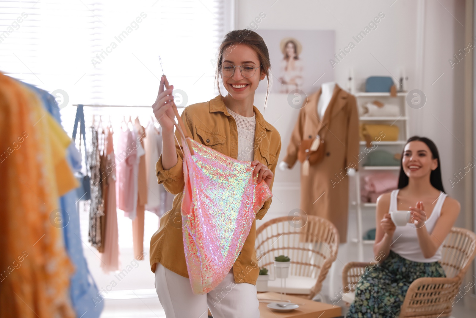 Photo of Young women choosing clothes in modern boutique