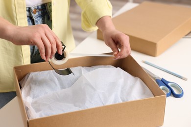 Seller preparing package at workplace, closeup view