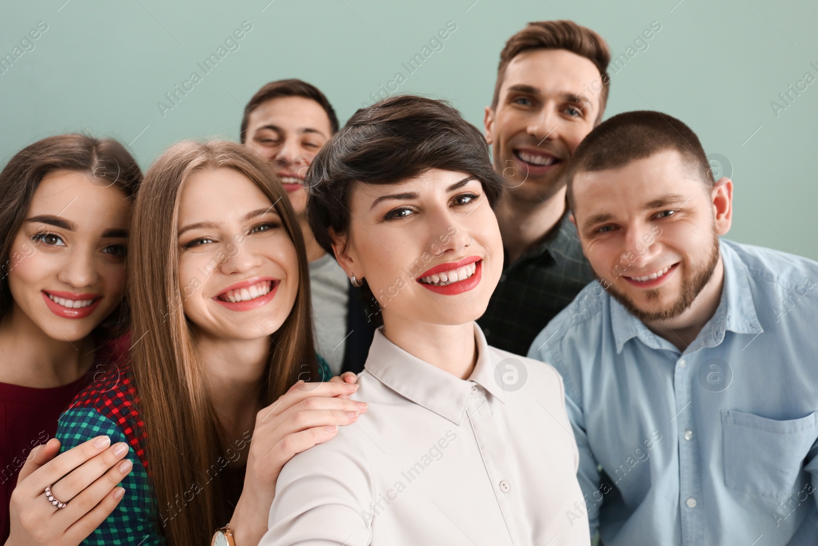 Photo of Happy friends taking selfie on color background