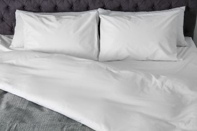 Photo of Bed with soft fluffy pillows at home