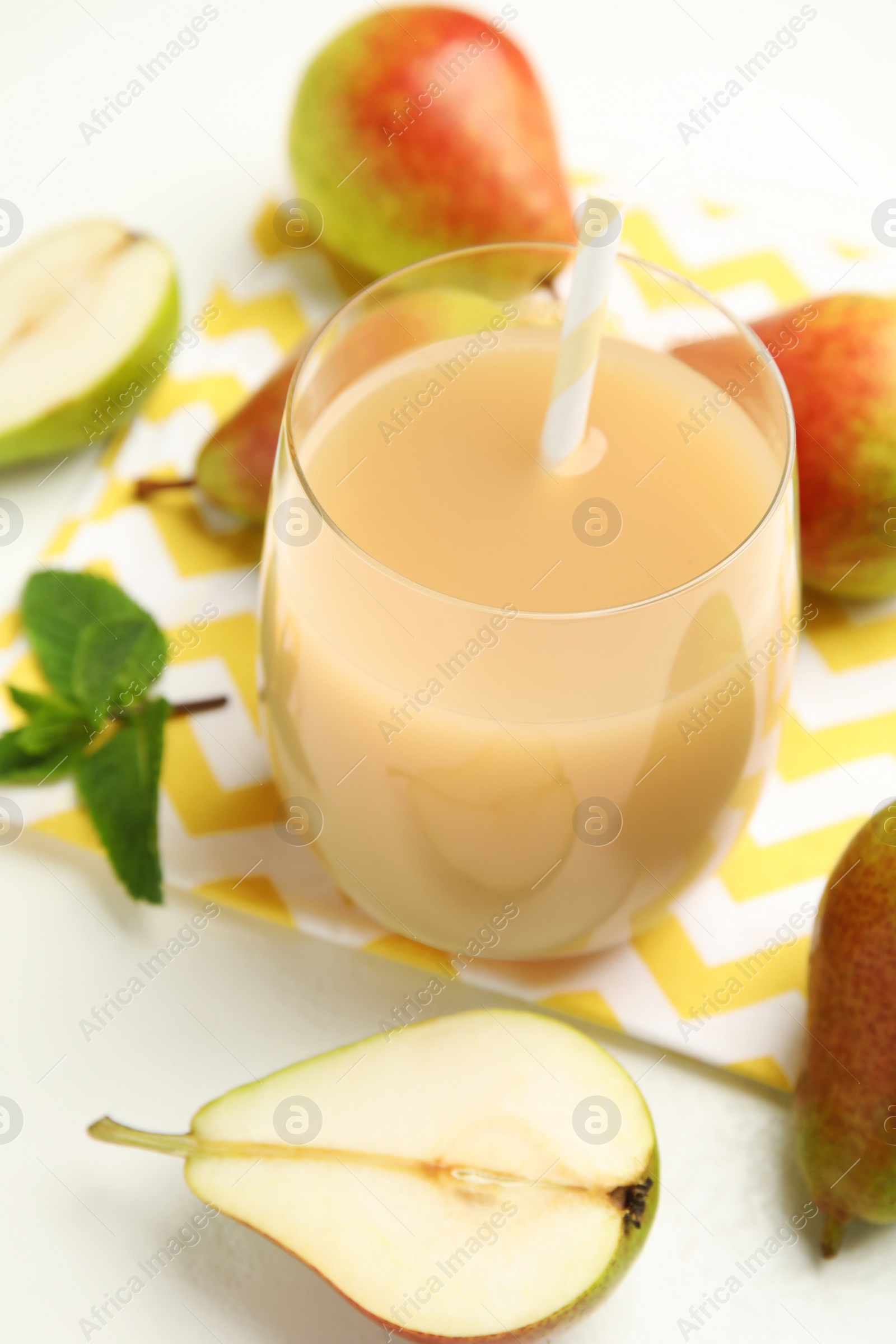 Photo of Tasty pear juice and fruits on white table, closeup