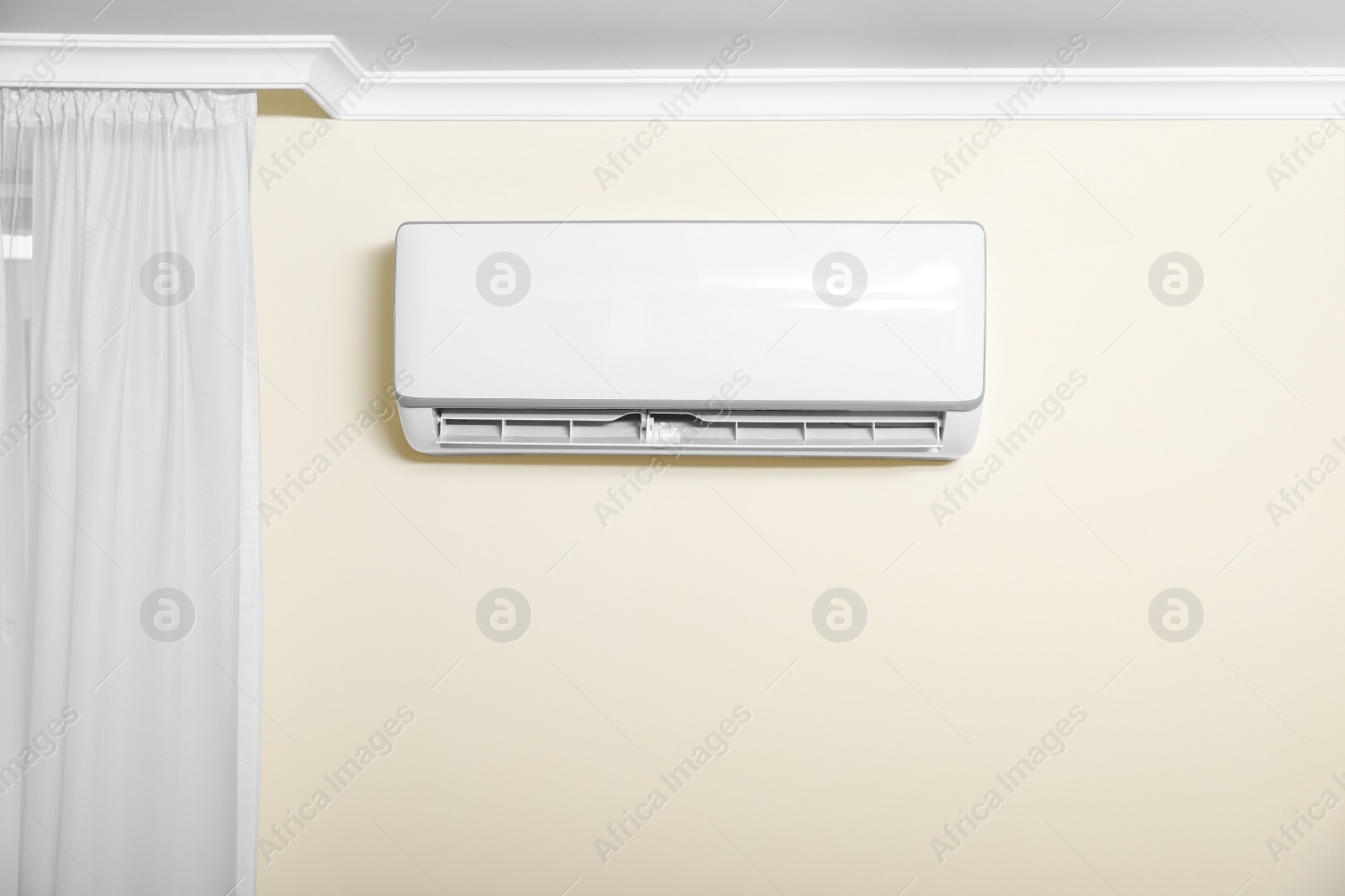 Photo of Modern air conditioner on white wall indoors