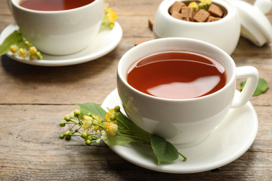 Cup of tea and linden blossom on wooden table