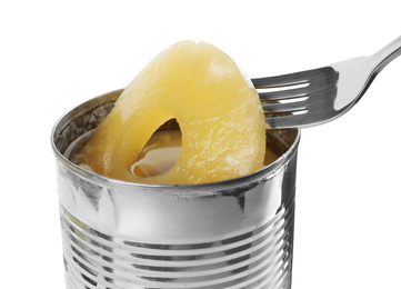 Photo of Taking canned pineapple ring from tin with fork on white background, closeup