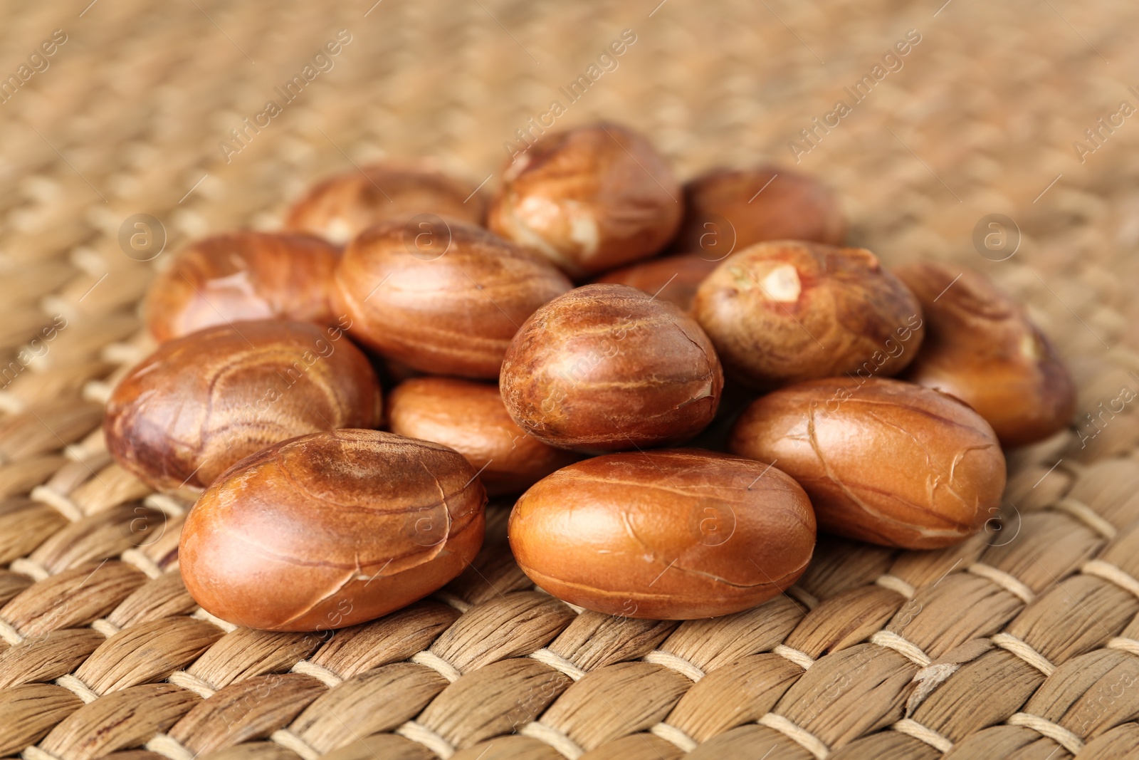 Photo of Many raw jackfruit seeds on wicker mat, closeup