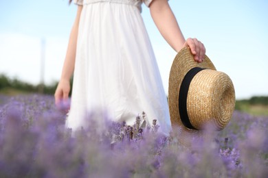 Photo of Young woman with straw hat in lavender field, closeup