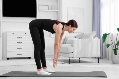 Photo of Morning routine. Woman doing stretching exercise at home