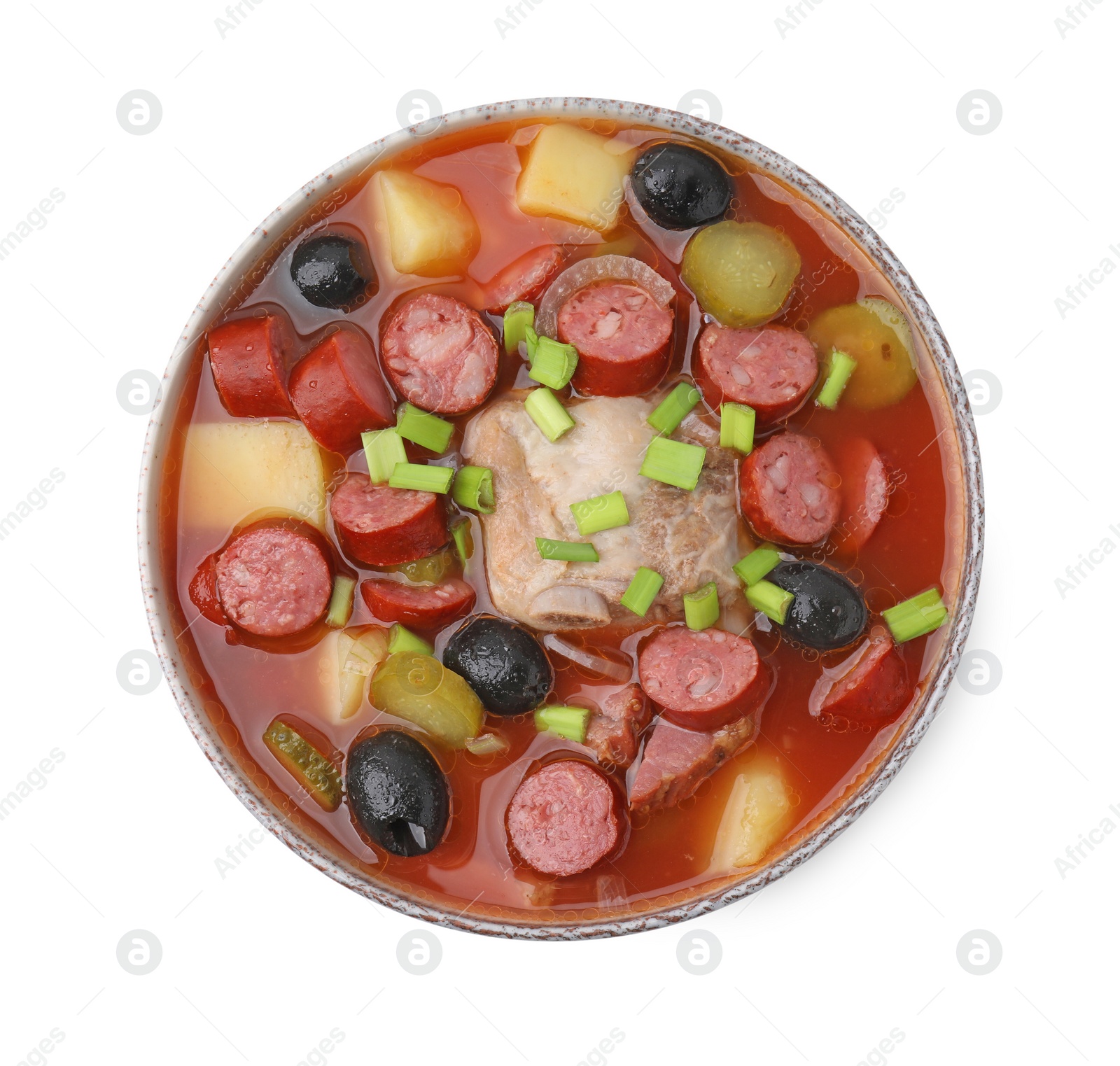 Photo of Meat solyanka soup with thin dry smoked sausages in bowl isolated on white