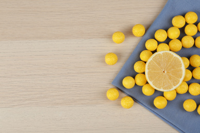 Photo of Flat lay composition with tasty lemon drops on wooden table. Space for text