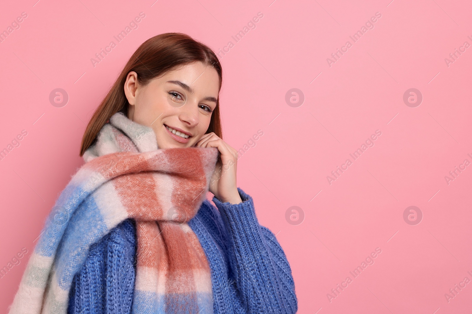 Photo of Beautiful woman in warm scarf on pink background, space for text