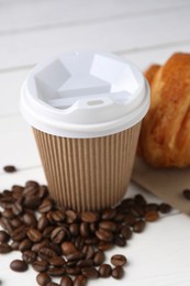 Photo of Coffee to go. Paper cup with tasty drink and beans on white table