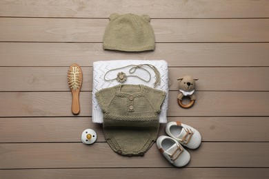 Photo of Flat lay composition with cute baby knitwear for photoshoot on wooden background