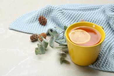 Composition with tea and warm plaid on light marble table, closeup