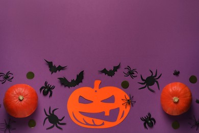 Flat lay composition with pumpkins, paper bats and spiders on purple background, space for text. Halloween celebration