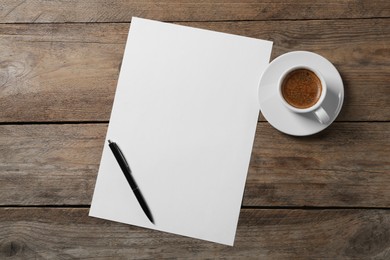 Blank paper sheet, pen and cup of coffee on wooden table, flat lay. Space for text