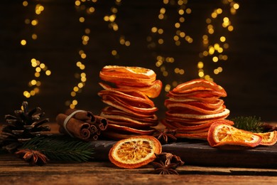 Dry orange slices, anise stars and cinnamon sticks on wooden table. Bokeh effect