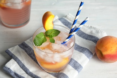 Photo of Tasty peach cocktail on table. Refreshing drink