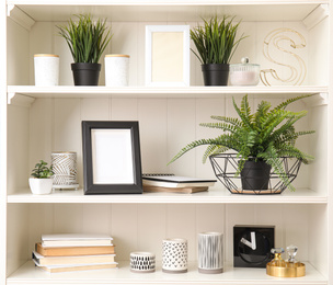 White shelving unit with plants and different decorative stuff