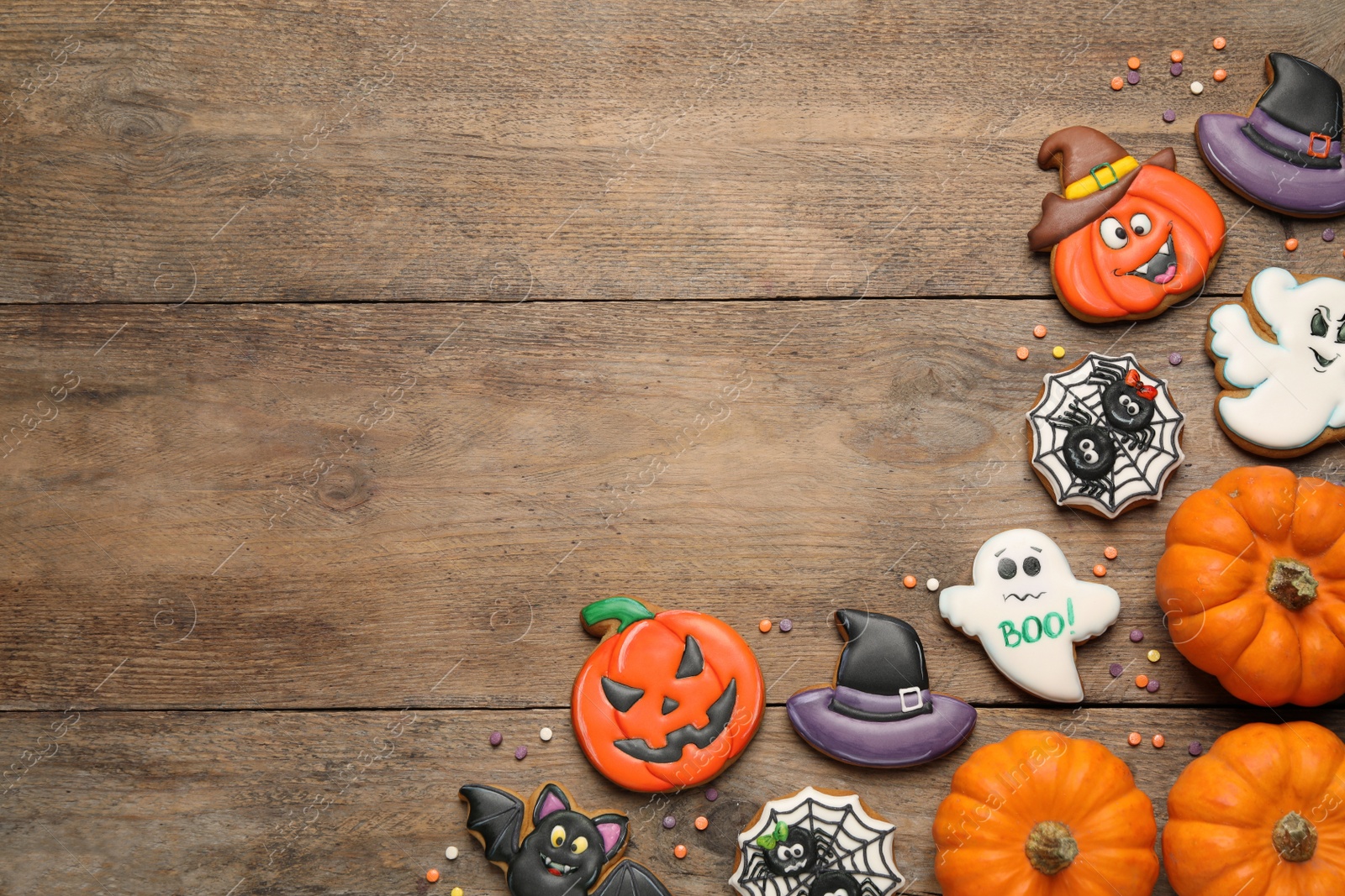 Photo of Tasty Halloween cookies on wooden table, flat lay. Space for text