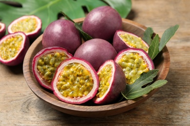 Photo of Cut and whole passion fruits (maracuyas) on wooden table