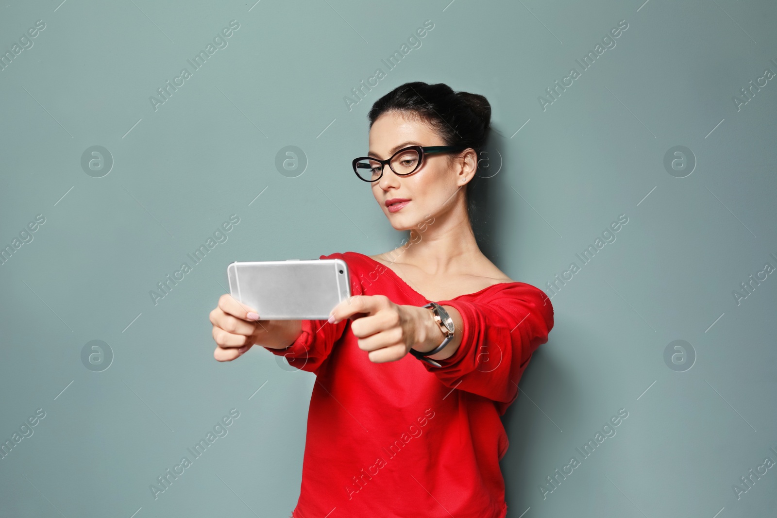 Photo of Attractive young woman taking selfie on grey background