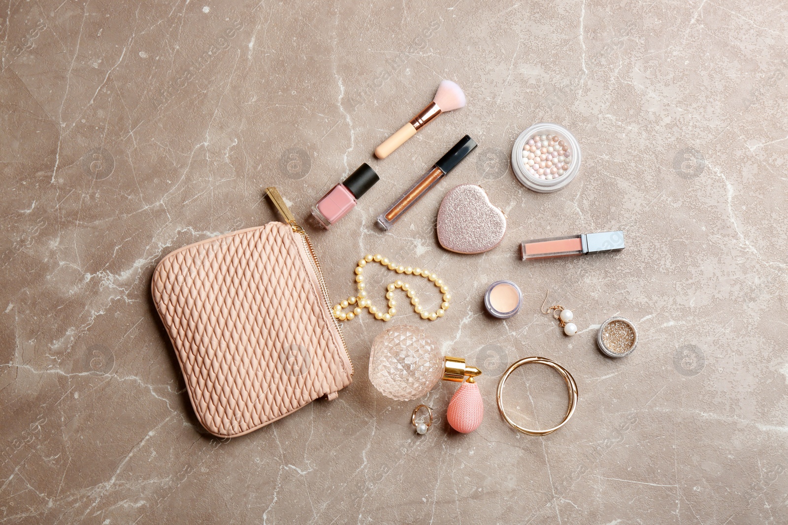 Photo of Flat lay composition with perfume, jewelry and cosmetic products on marble table