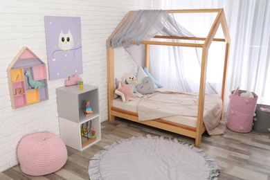 Photo of Cute child's room interior with toys and modern furniture