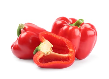 Whole and cut red bell peppers on white background