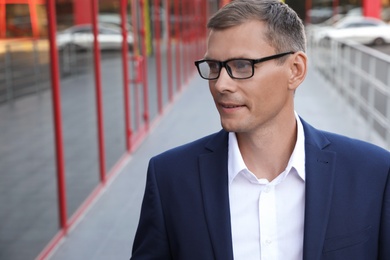 Photo of Businessman near modern building on city street