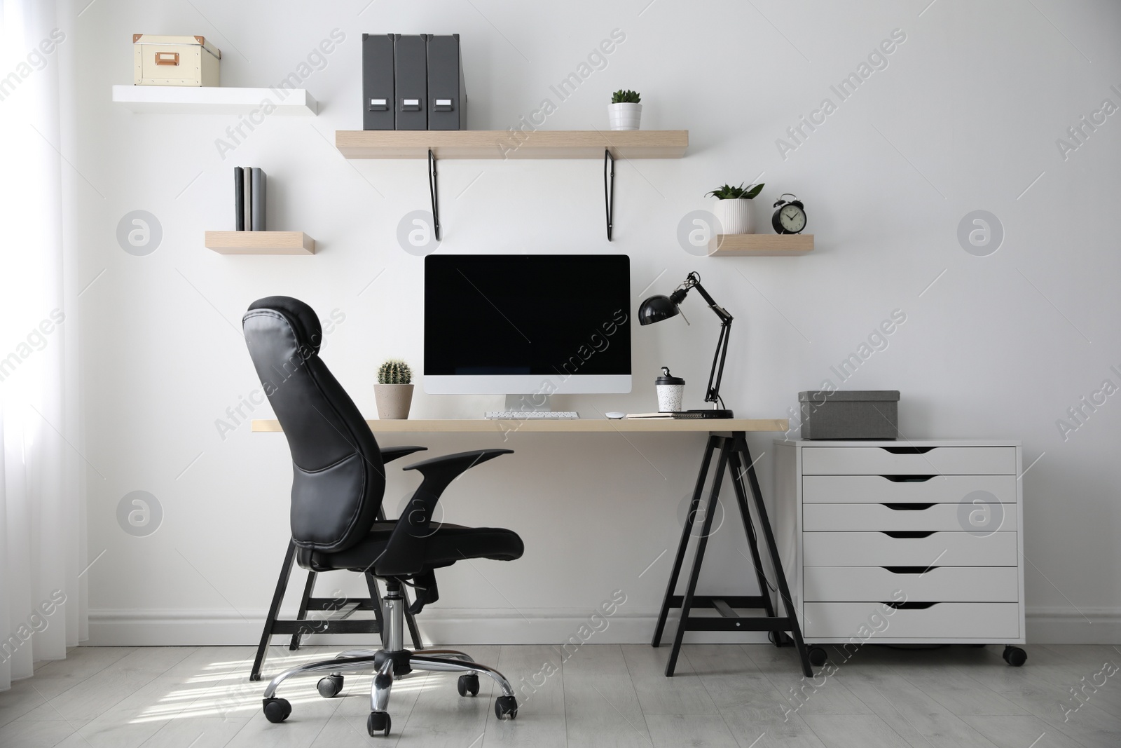 Photo of Comfortable office chair near table with modern computer