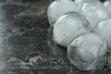Many frozen ice balls on black marble table, closeup. Space for text
