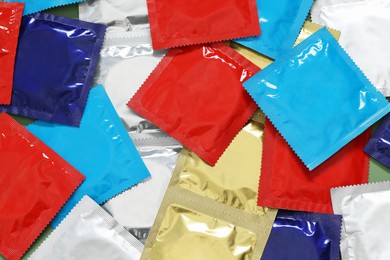 Photo of Packaged condoms as background, top view. Safe sex