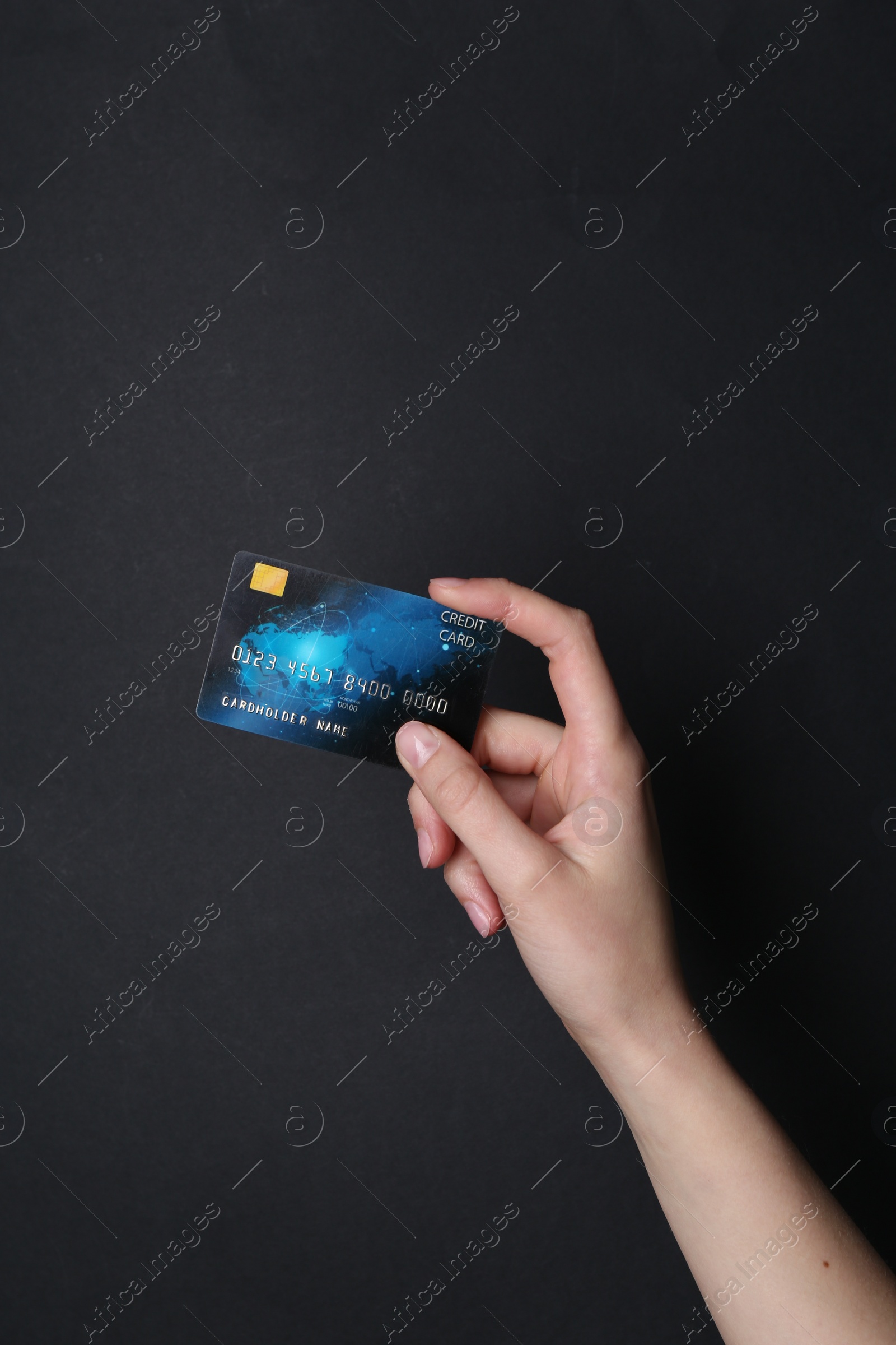 Photo of Woman holding credit card on black background, closeup