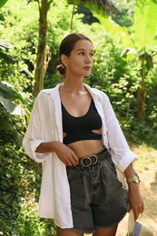 Photo of Beautiful young woman walking in green tropical park