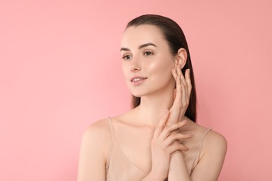 Portrait of beautiful young woman on pink background