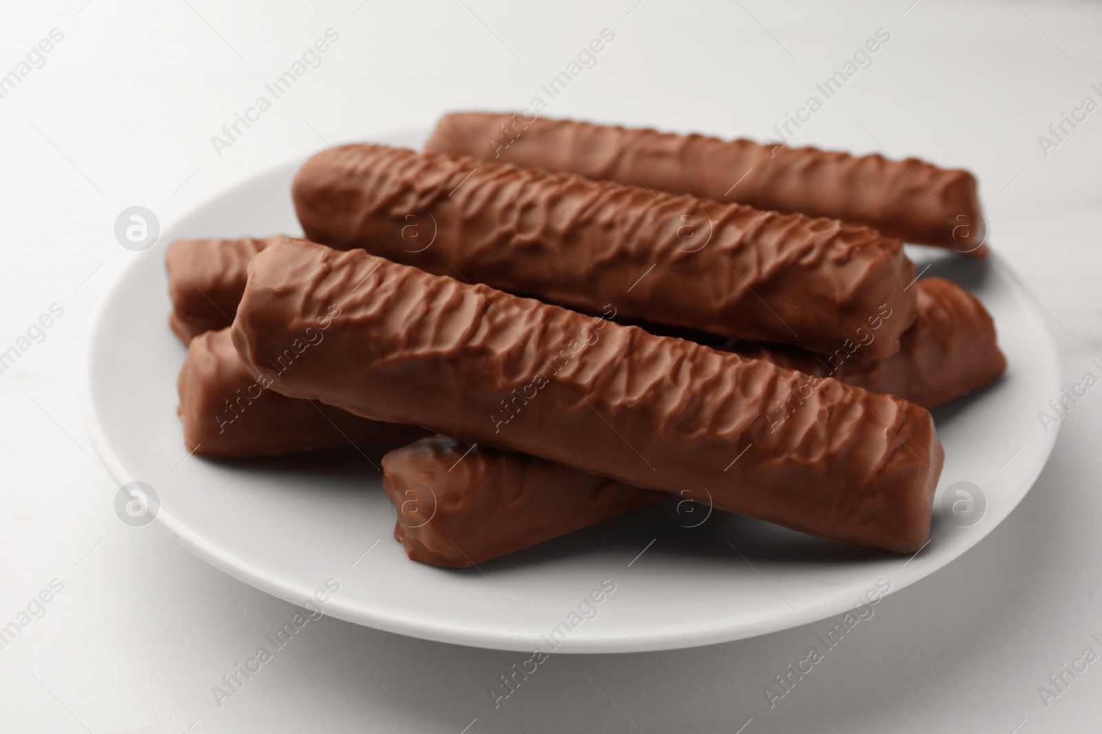 Photo of Sweet tasty chocolate bars on white table