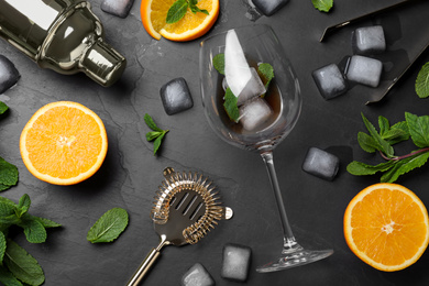 Photo of Flat lay composition with ingredients for cocktail and bartender's tools on black table