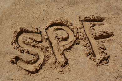 Photo of Abbreviation SPF written on sand at beach