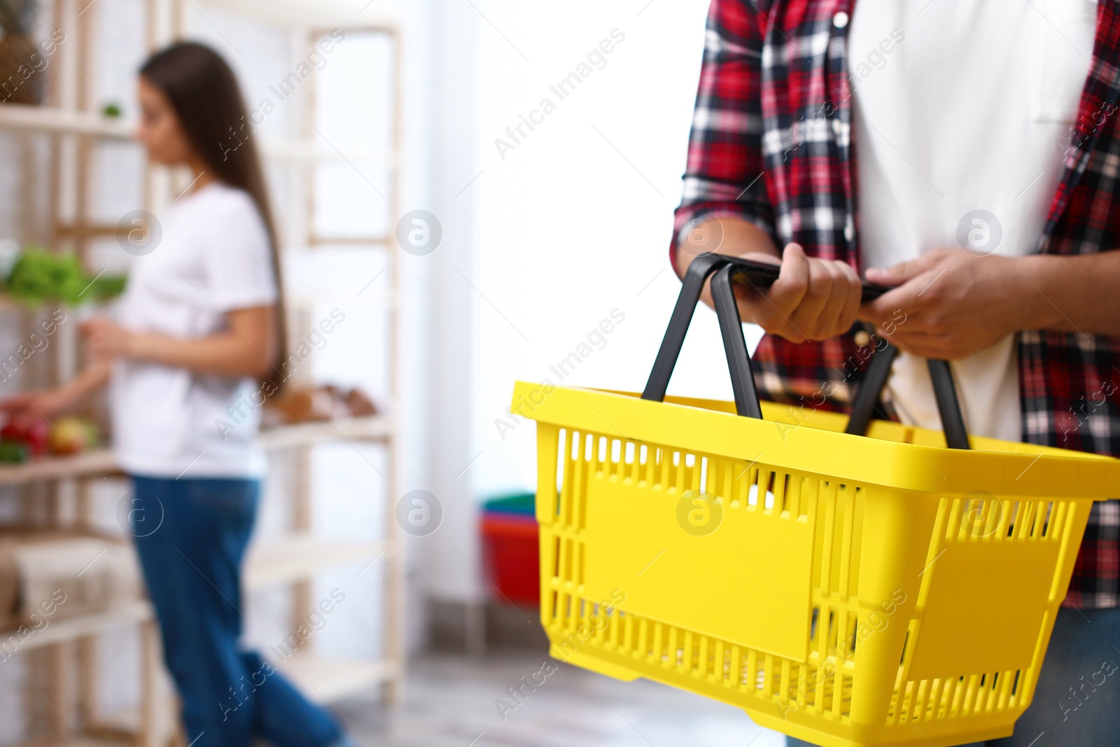 Photo of Man with empty shopping basket in grocery store, closeup