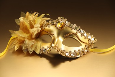 Photo of Beautifully decorated face mask on beige background. Theatrical performance