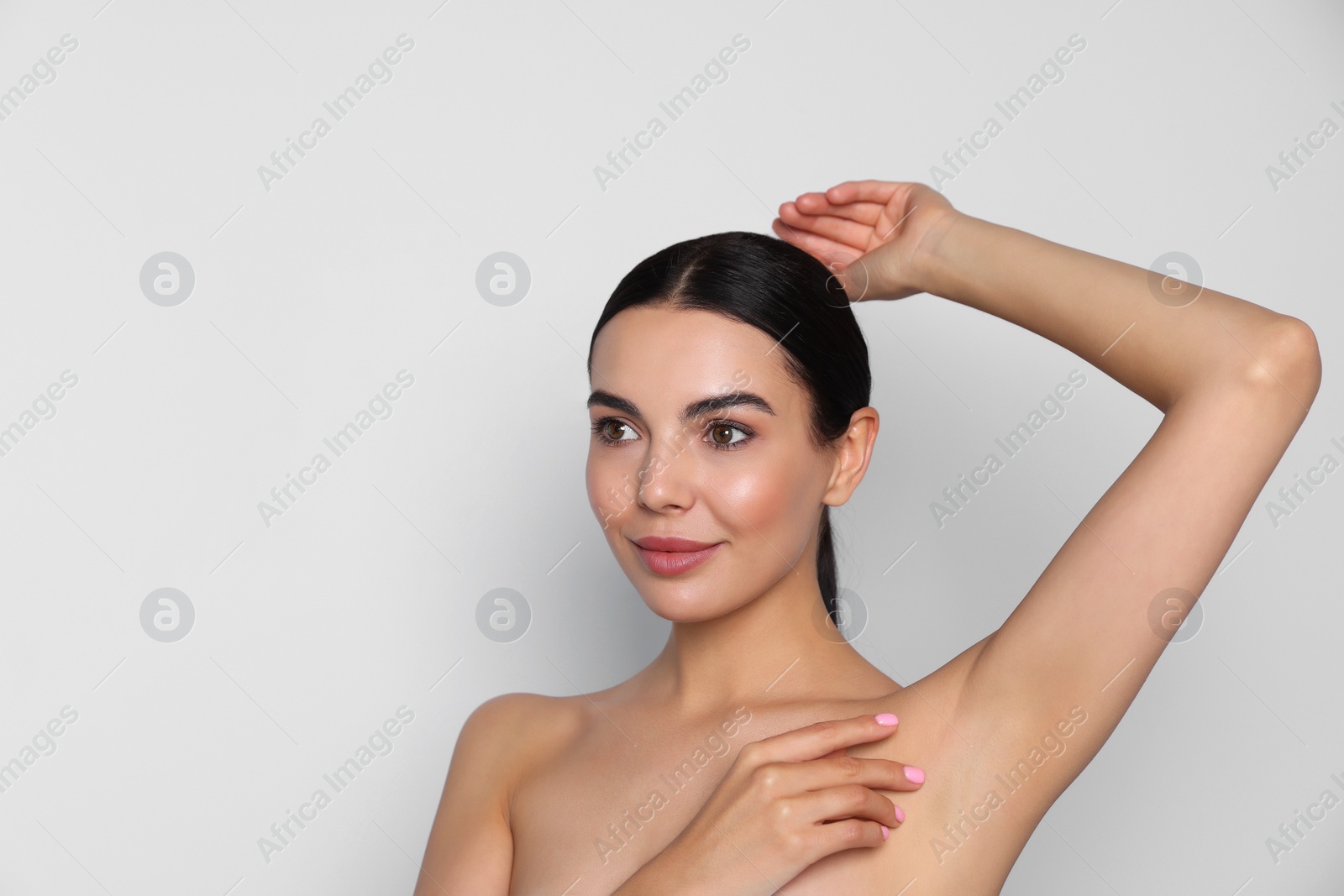 Photo of Young woman showing smooth skin after epilation on white background, space for text