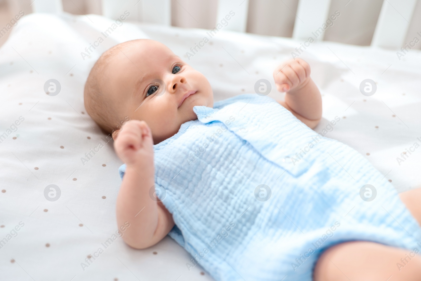 Photo of Cute little baby lying in crib at home