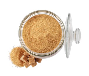 Photo of Granulated and cubed brown sugar with jar on white background, top view