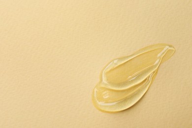 Photo of Swatches of cosmetic gel on beige background, closeup. Space for text