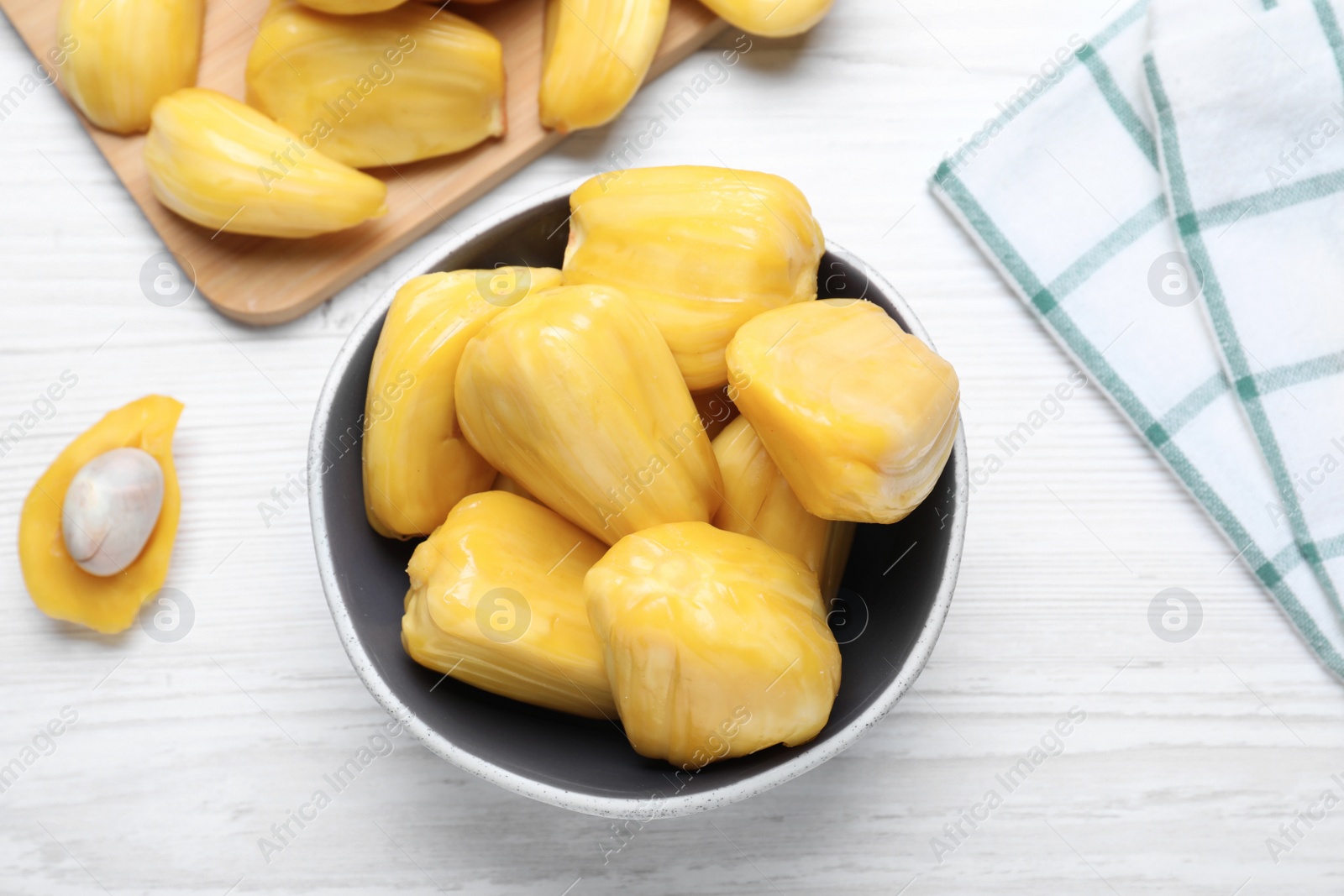Photo of Delicious exotic jackfruit bulbs on white wooden table, flat lay