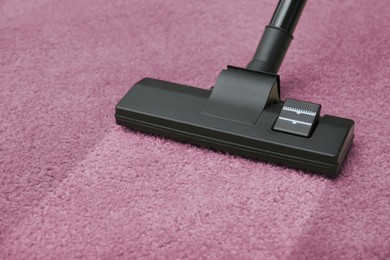 Image of Vacuuming dirty pink carpet. Clean area after using device, closeup