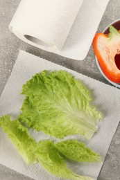 Photo of Paper towels and lettuce on grey table, flat lay