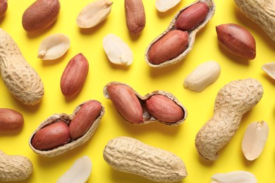 Fresh peanuts on yellow background, flat lay